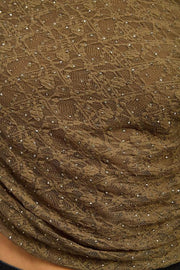 Close-up of a olive textured fabric with small embellishments