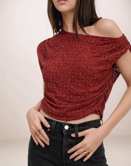 Woman wearing a red off-shoulder top against a beige background