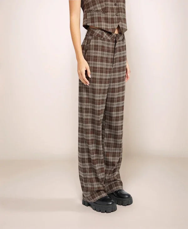 Person wearing plaid pants and a matching top against a plain background