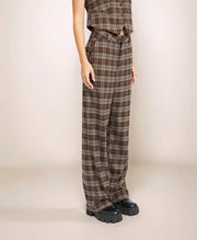Person wearing plaid pants and a matching top against a plain background