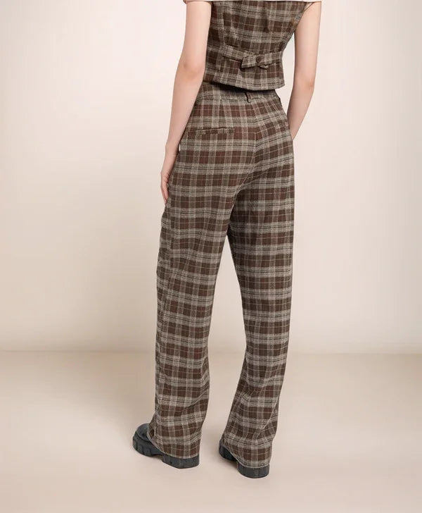 Person wearing plaid pants on a beige background