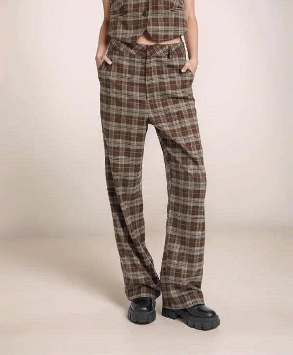 Plaid pants worn by a person on a beige background