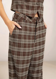 Brown plaid pants worn by a person on a plain background