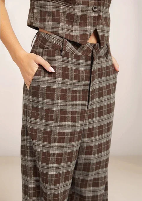 Brown plaid pants worn by a person on a plain background