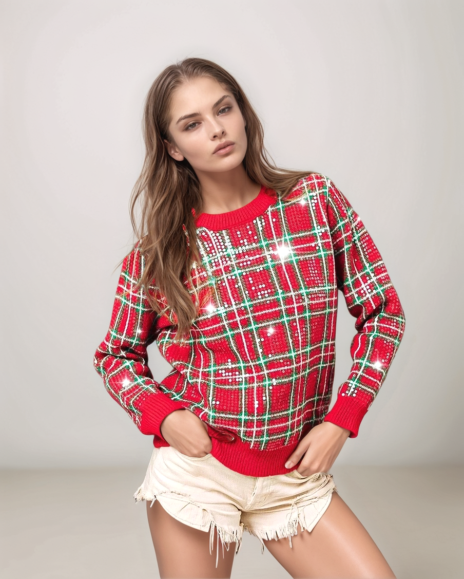 Woman wearing a red and green plaid sweater with sequins on a light gray background