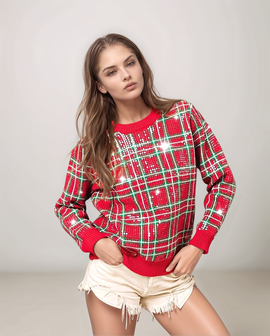 Woman wearing a red and green plaid sweater with sequins on a light gray background