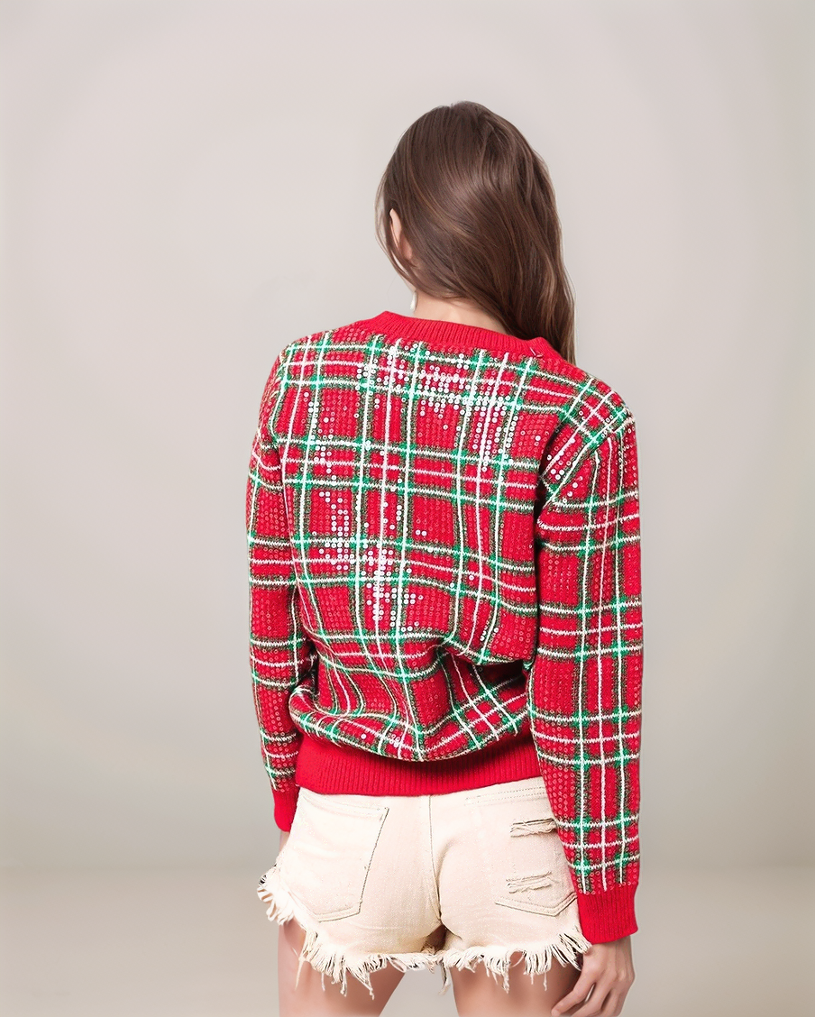 Person wearing a red and green plaid sweater with a plain background