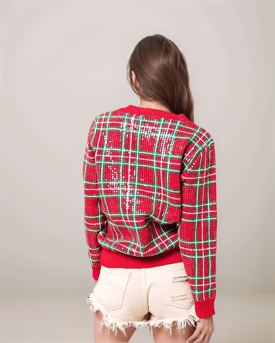 Person wearing a red and green plaid sweater with a plain background