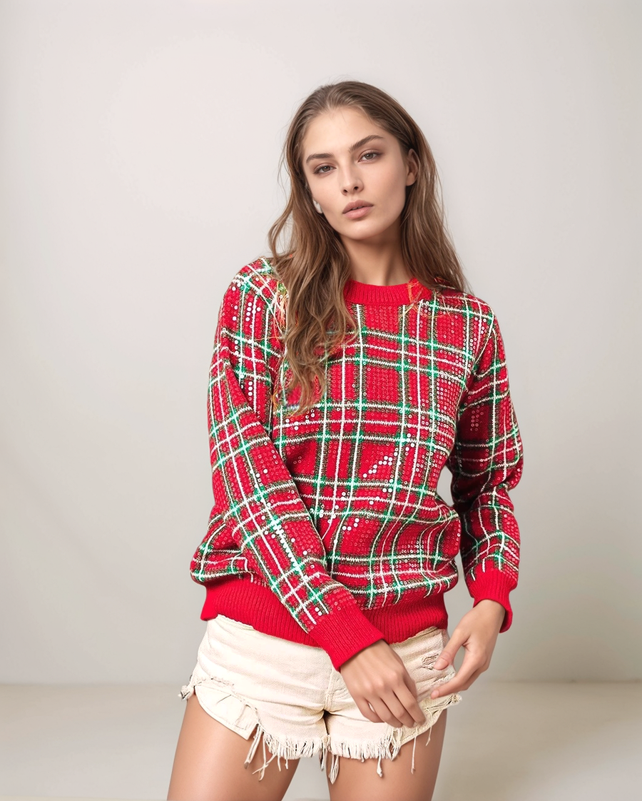 Woman wearing a red and green plaid sweater with a plain background