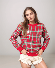 woman wearing a tartan sparkle sweater with white shorts 