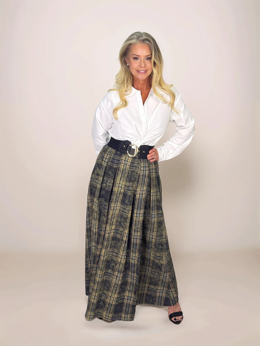 Woman wearing a white shirt and plaid skirt on a plain background