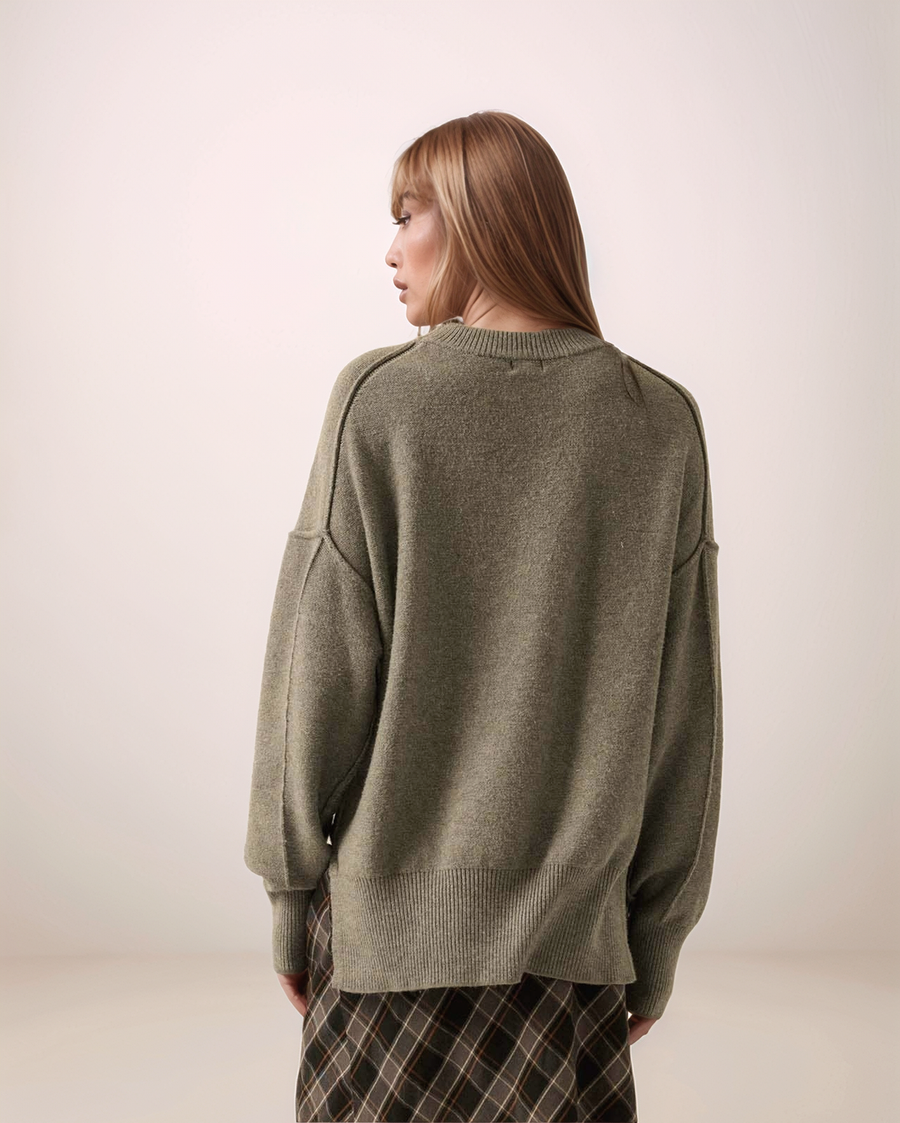 Person wearing a gray sweater with a neutral background