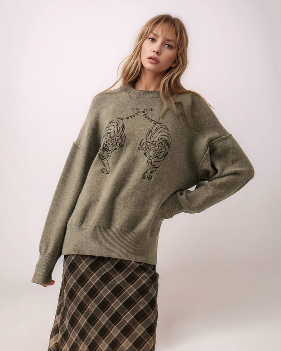 Woman wearing a gray sweater with tiger designs on a white background