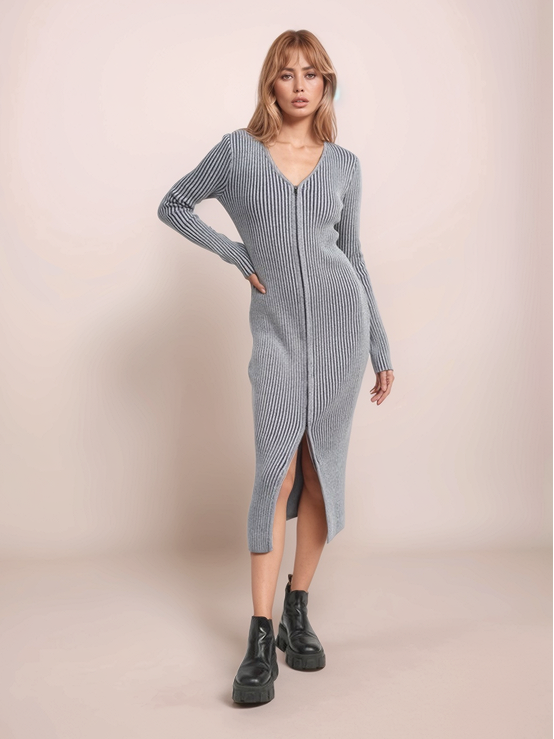 Woman wearing a long ribbed knit dress with a slit on a beige background