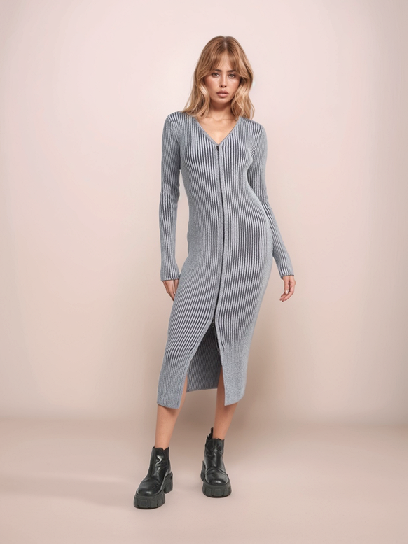 Woman wearing a long ribbed knit dress against a plain background