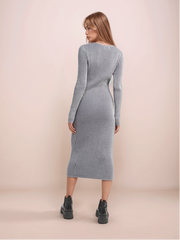 Woman wearing a ribbed knit dress against a plain background