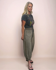 Fashionable woman in a casual-chic outfit featuring a graphic tee and comfortable, stylish light gray cropped barrel leg sweatpants