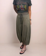 a woman wearing stylish and comfortable cropped barrel leg sweatpants with a graphic t-shirt and sandals