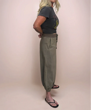 Blonde stylish woman facing sideways wearing a graphic t-shirt and stylish, comfortable cropped sweatpants.