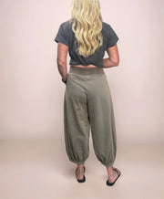 a blonde woman facing backwards wearing stylish cropped sweatpants with a cropped t-shirt and sandals