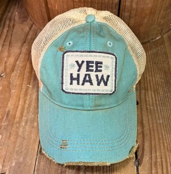 Blue cap with 'YEE HAW' patch on a wooden surface