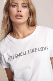 Person wearing a white t-shirt with text on a plain background